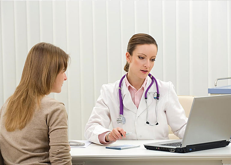 Пациентка и врач смотрят в ноутбук